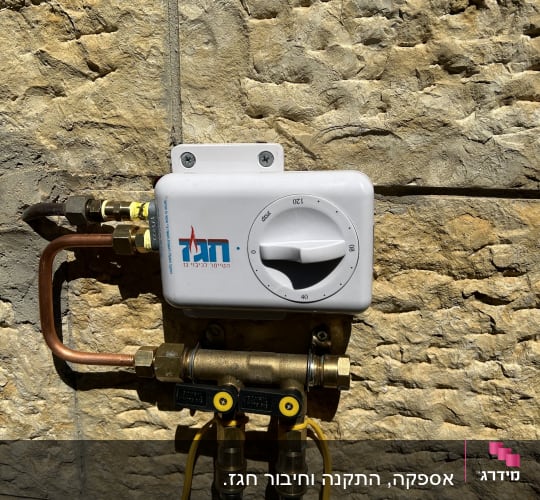 מד חום גז על קיר אבן עם צינורות נחושת